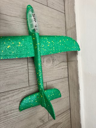 Avión de juguete verde con luces. Planeador