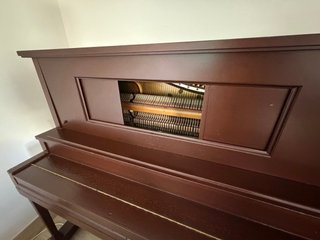 Piano vertical madera oscura.