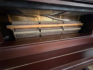 Piano vertical madera oscura.