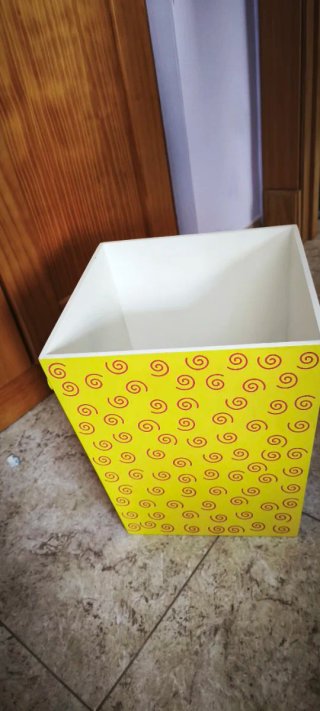 Papelera de madera amarilla con espirales
