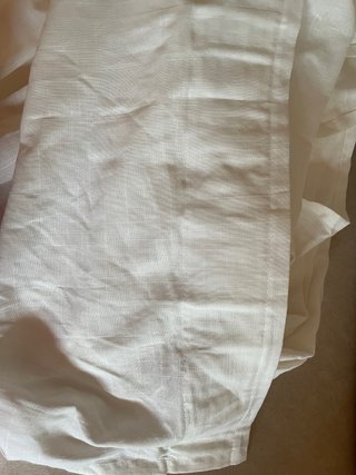 Cortina de tela blanco roto.