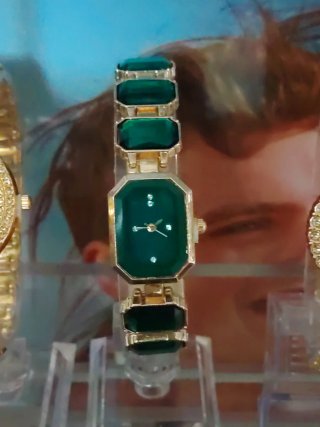 Reloj de mujer dorado con detalles verdes