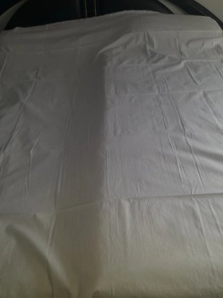 Una sábana y cojineras blancas