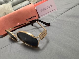 Gafas de sol Miu Miu doradas y negras