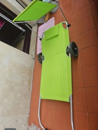 Silla de playa con parasol y ruedas.
