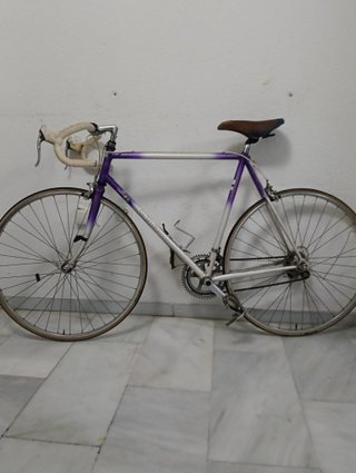 Bicicleta de carretera morada y blanca