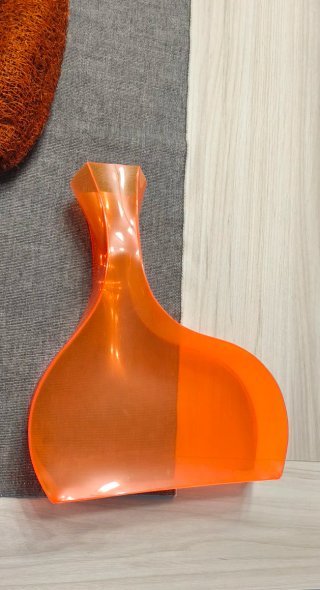 Jarrón plástico naranja con flores secas