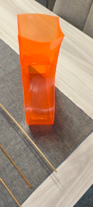 Jarrón plástico naranja con flores secas