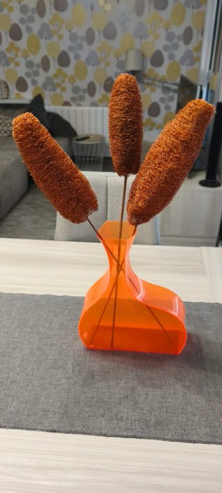 Jarrón plástico naranja con flores secas