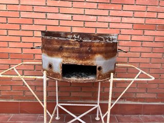 Barbacoa redonda con soporte de hierro.