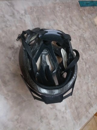 Casco de bici plateado y rosa con luz roja.