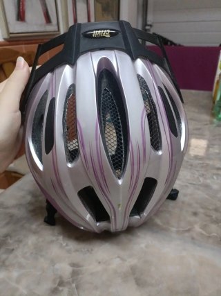 Casco de bici plateado y rosa con luz roja.