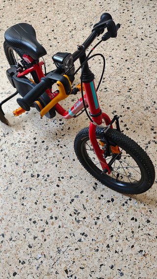 Bicicleta infantil roja con ruedines