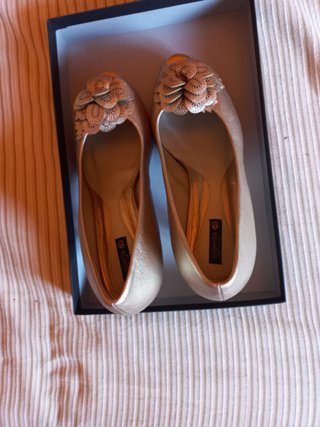 Zapatos dorados de tacón con flor