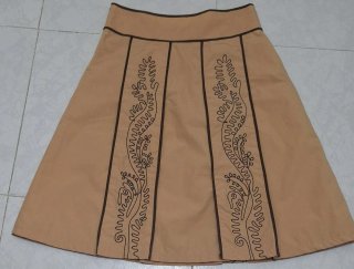 Falda beige con bordado marrón.