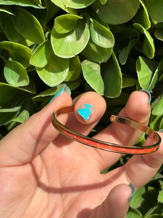 Pulsera dorada con detalles naranjas