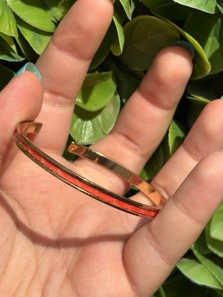 Pulsera dorada con detalles naranjas
