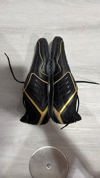 Botas de fútbol multitaco negras y doradas