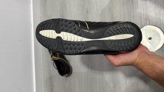 Botas de fútbol multitaco negras y doradas