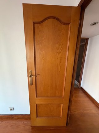 Puerta de roble con manillas doradas.
