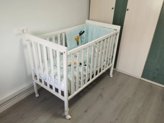 Cuna de bebé blanca con ruedas