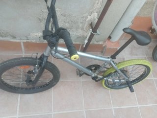 Bicicleta BMX plateada con ruedas amarillas