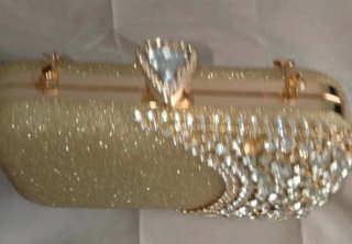 Bolso de mano dorado con pedrería