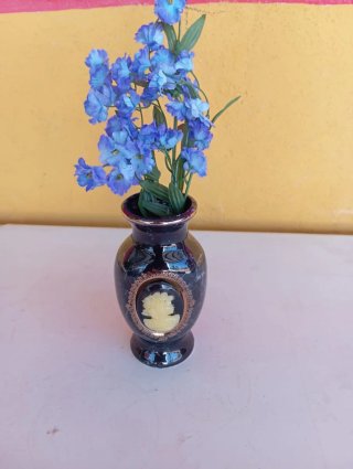 Florero negro con flores azules