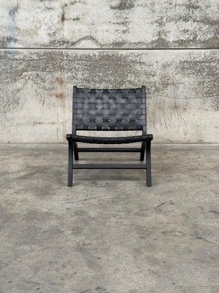 Sillón Calixta de piel y madera maciza de caoba con acabado pintado negro.