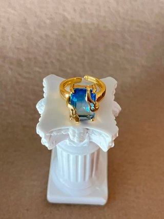 Anillo con piedra azul y detalles dorados