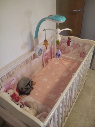 Cuna de bebé con peluches y móvil