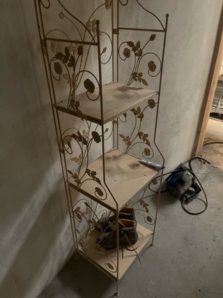 Estantería de metal beige con diseño floral