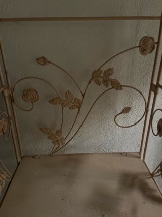 Estantería de metal beige con diseño floral