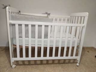 Cuna de bebé blanca con ruedas