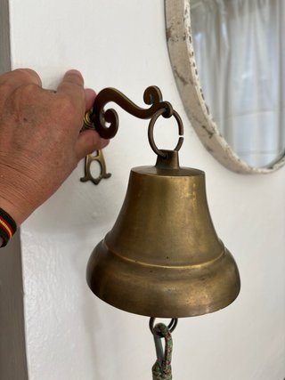 Campana de latón con cuerda y bola decorativa