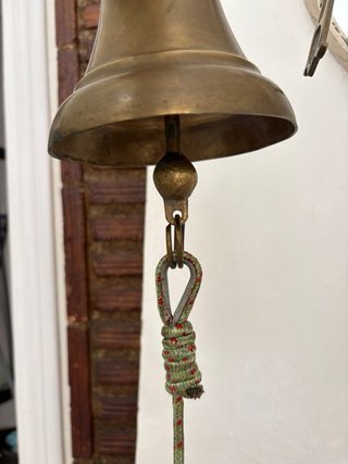 Campana de latón con cuerda y bola decorativa