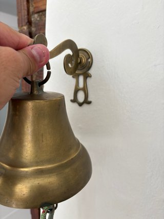 Campana de latón con cuerda y bola decorativa