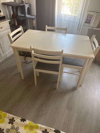 Mesa de comedor con mantel y las cuatro sillas