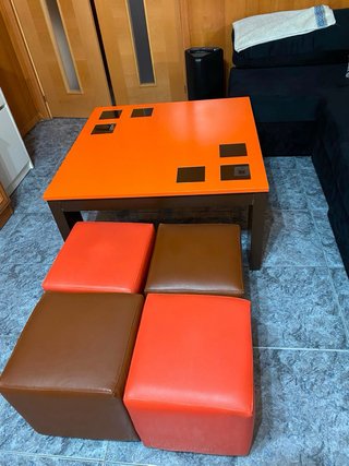 Mesa centro con 4 puffs naranja.