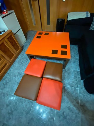 Mesa centro con 4 puffs naranja.
