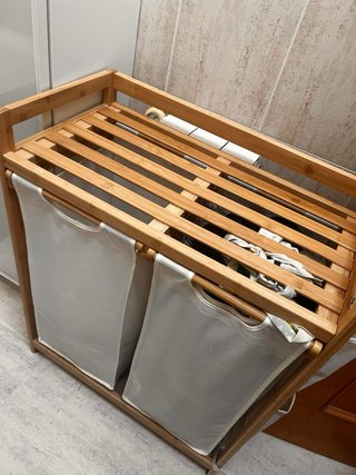 Mueble de baño y armario nuevo con cesta de ropa.