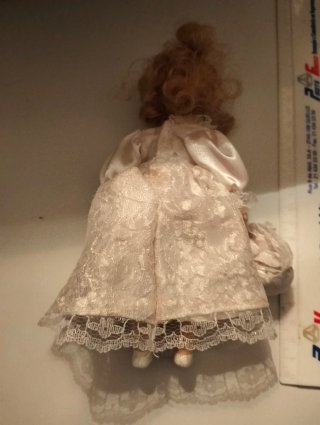 Boneca de porcelana com vestido de renda