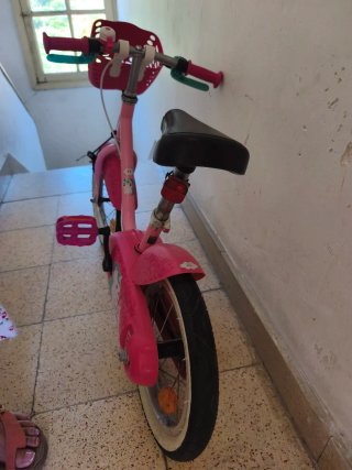 Bicicleta infantil rosa con cesta y casco