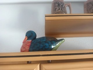 Figura de pato decorativa pintada.