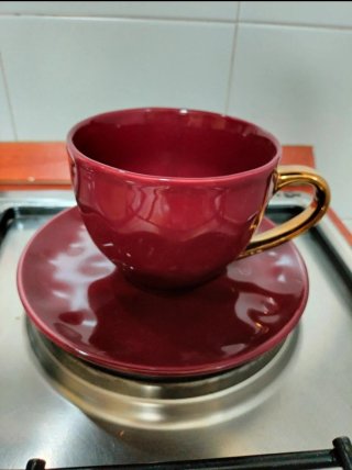 Tazza da tè in ceramica rossa con manico dorato