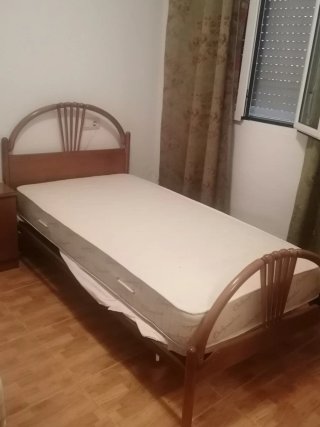 Cama antigua de madera con colchón rosa