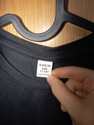 Camiseta negra con cara sonriente rosa