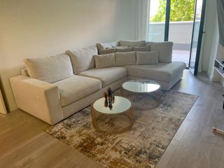 Sofá modular beige y mesas centro doradas