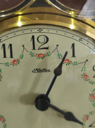 Reloj de péndulo antiguo con campana de cristal