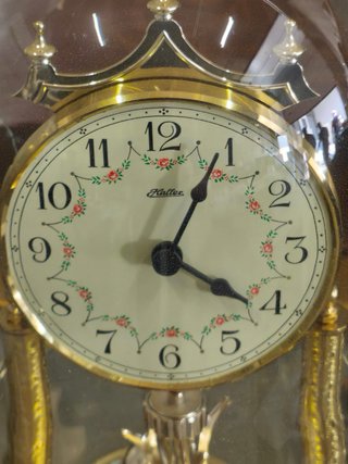 Reloj de péndulo antiguo con campana de cristal